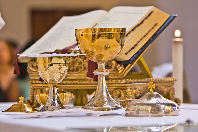Bible and chalice at church altar